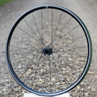 Bicycle wheel with gravel road background.